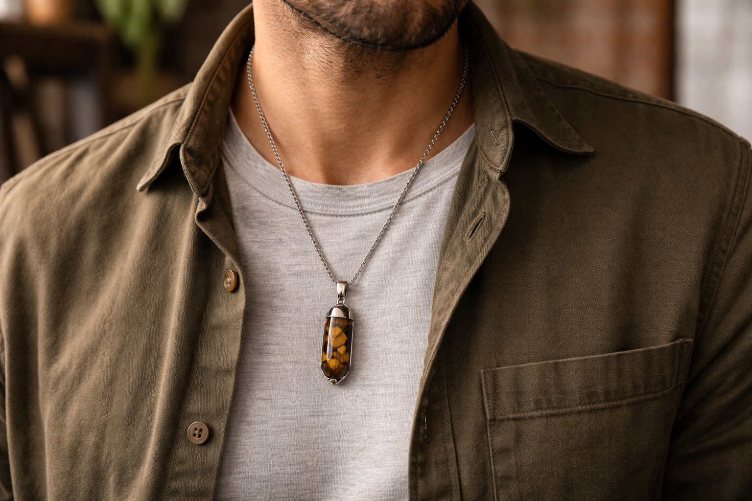 Man wearing a subtle crystal pendant necklace with a plain tee and open-collar shirt for everyday styling